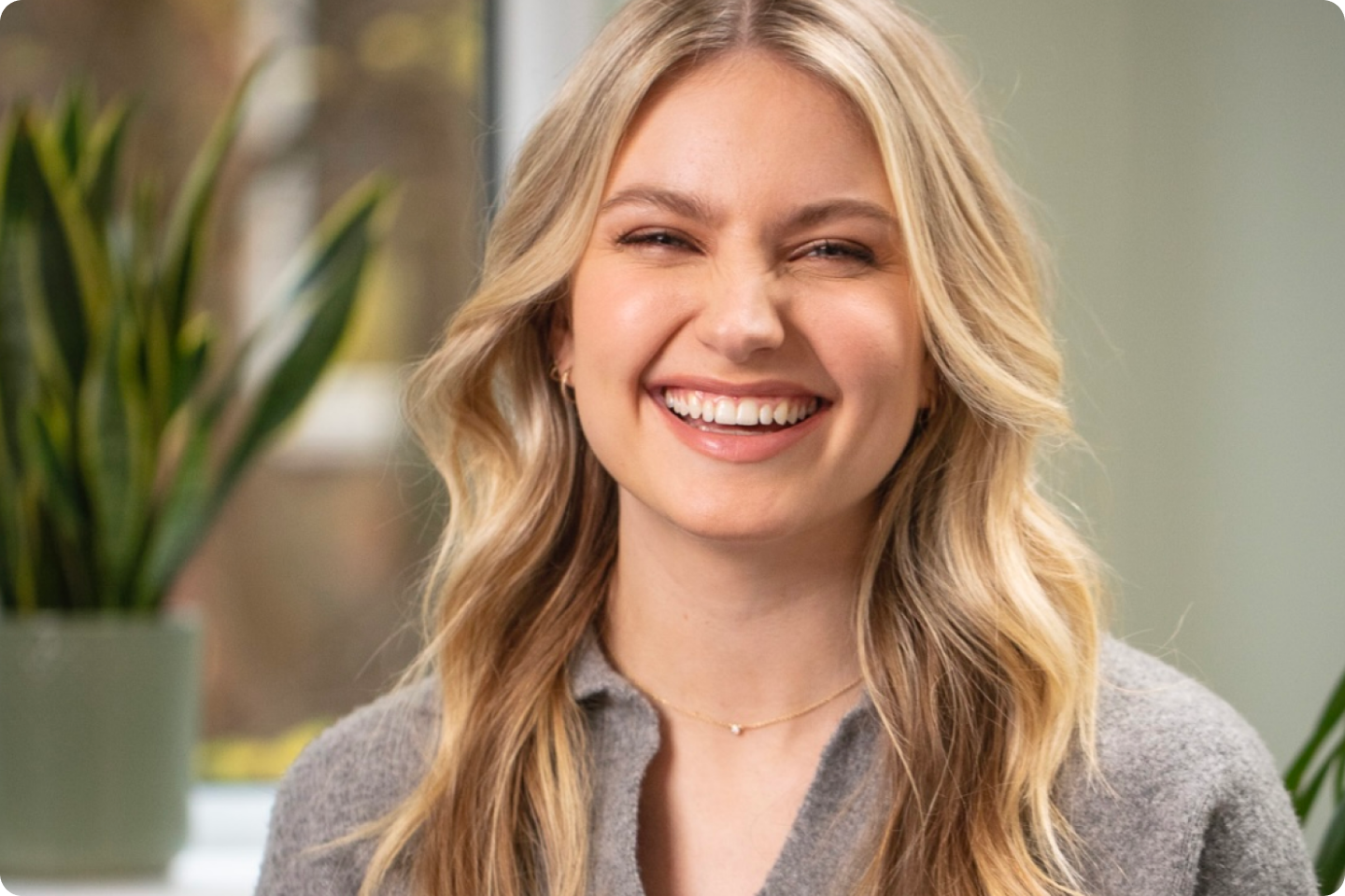 Photo of Amy smiling at the camera, she has long blonder hair with natural waves