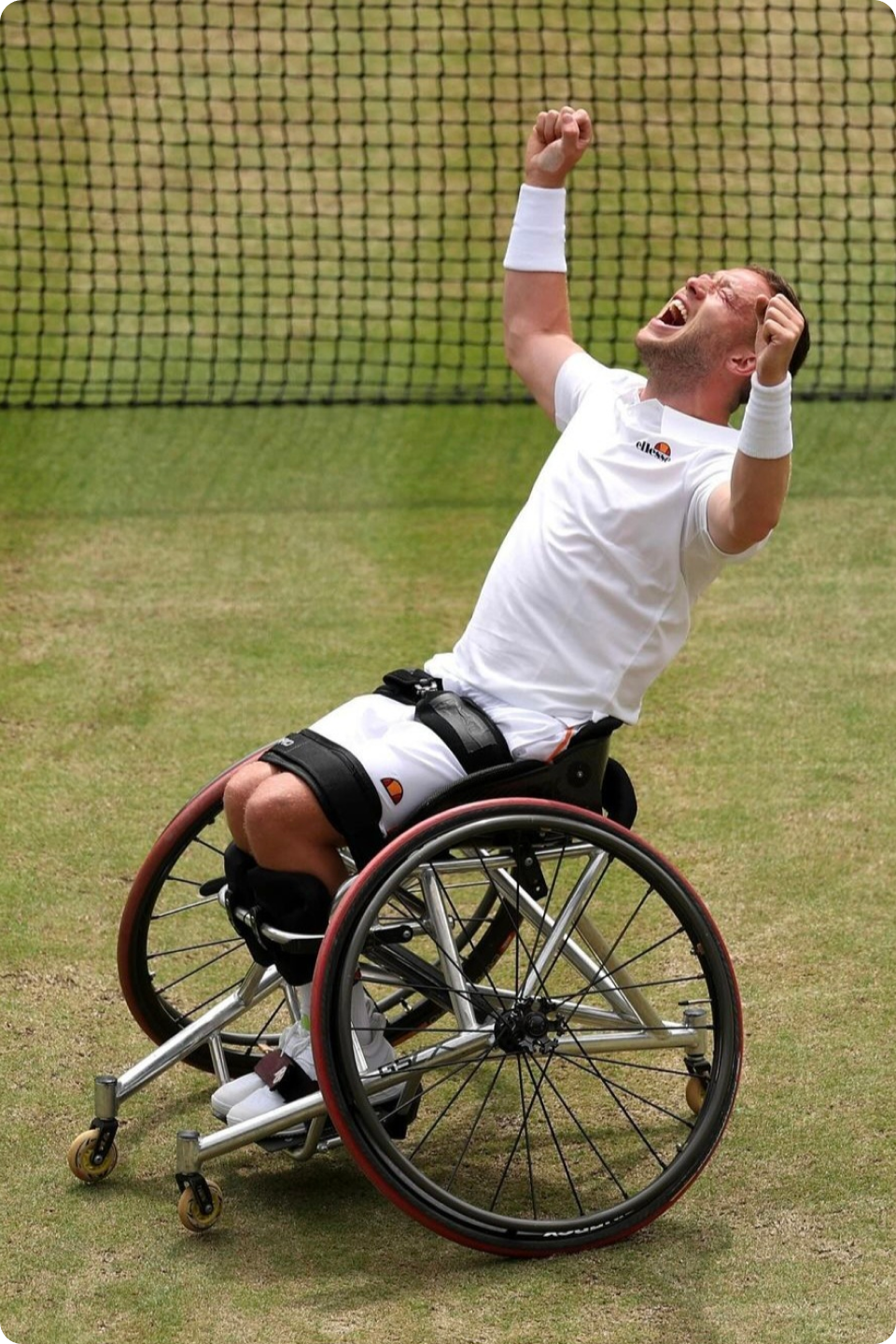 Photo of Alfie Hewett in his wheelchair on the court - celebrating with his arms up in the air