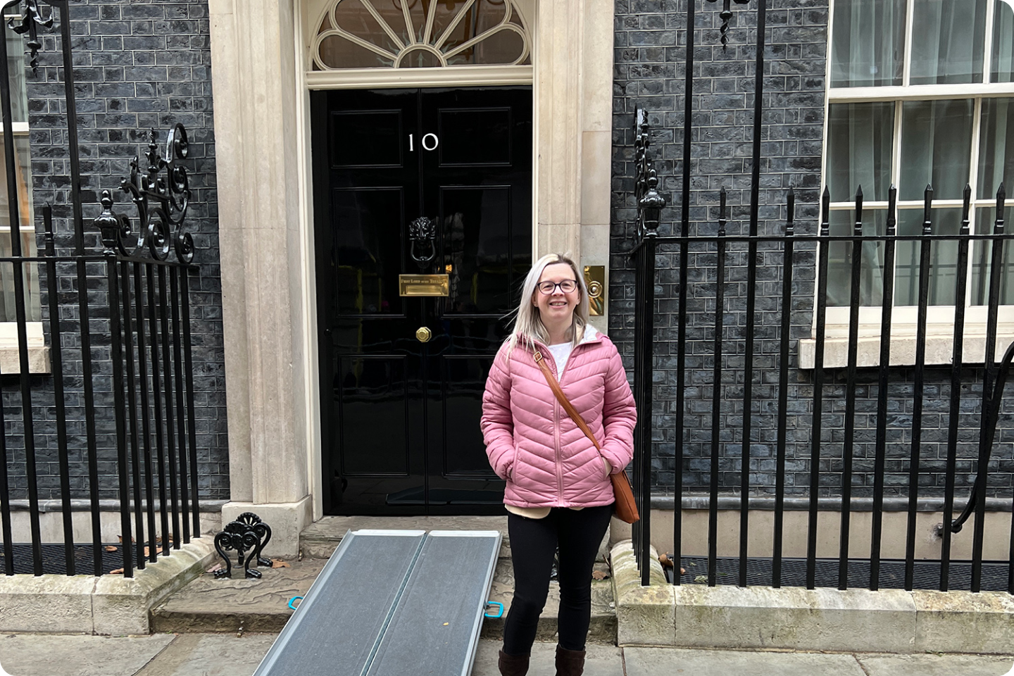 Hayley outside number 10 Downing Street. She has long blonde hair.