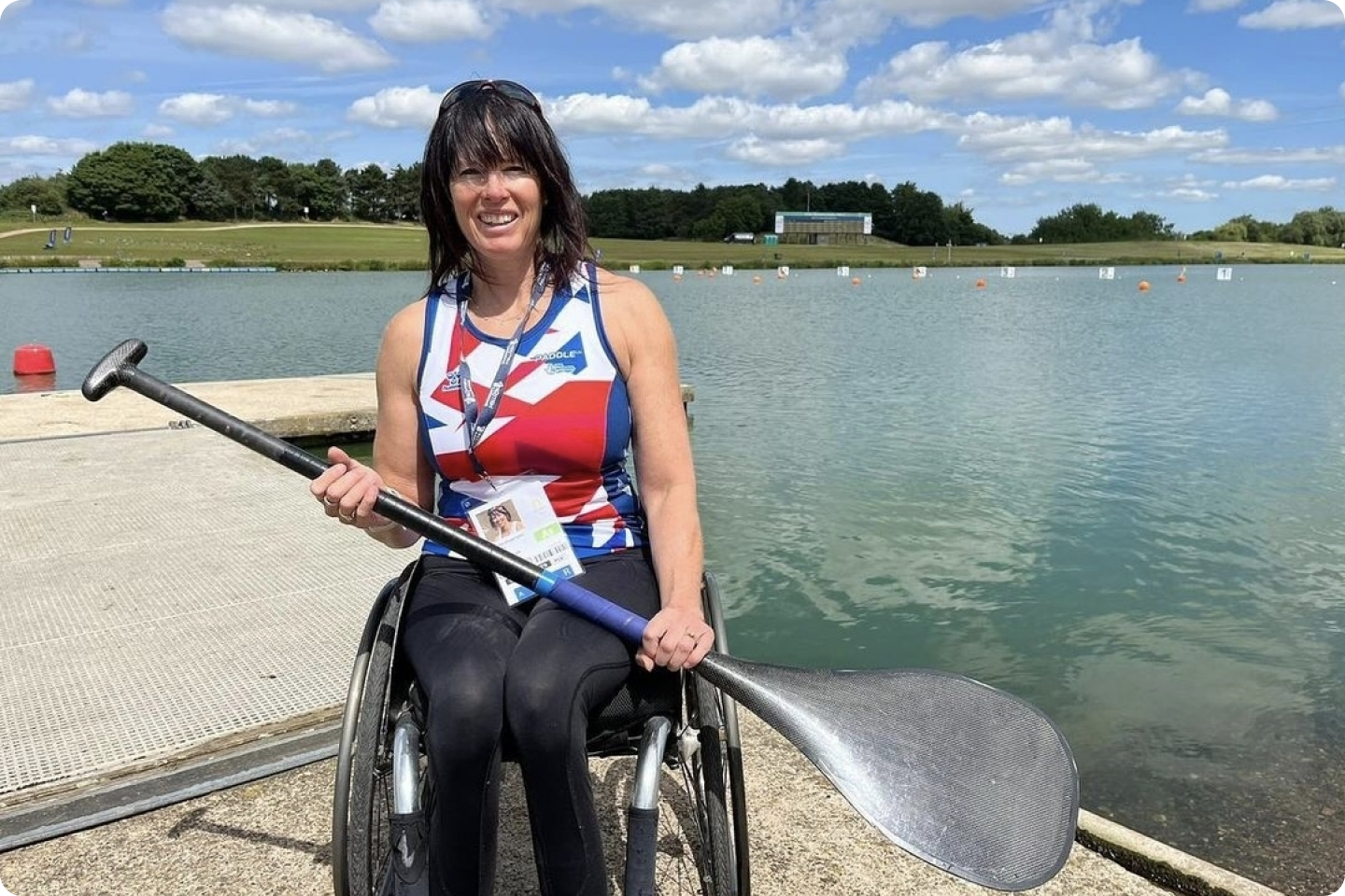 Photo of Jeanette Chippington in her wheelchair holding her oar