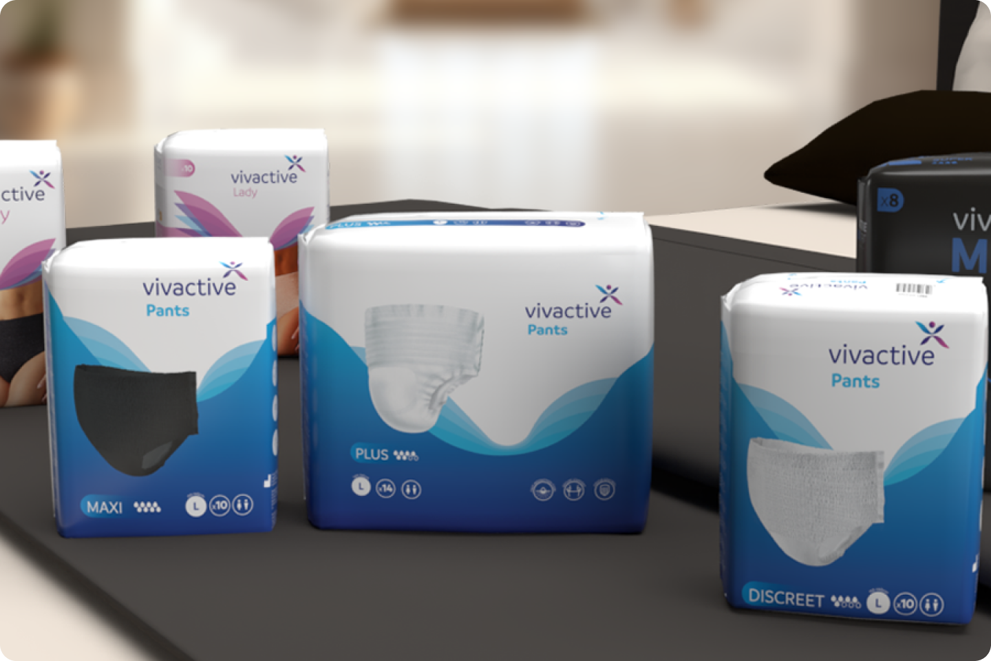 A display of vivactive incontinence products on a table includes various types of pants and protective wear. The packaging features the brand logo and different models for varied absorbency levels, such as "MAXI," "PLUS," and "DISCREET.