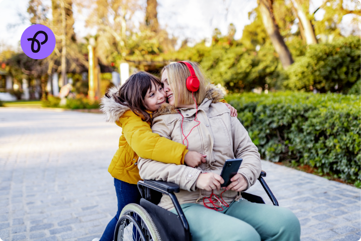 A mother and daughter outdoors are hugging, the mum is a wheelchair user for a post about how can disabled people stay active and keep warm in winter 