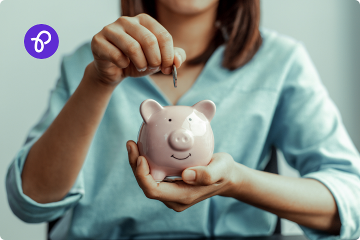 A woman putting a coin in a piggy bank for a blog about disabled people and money saving for christmas