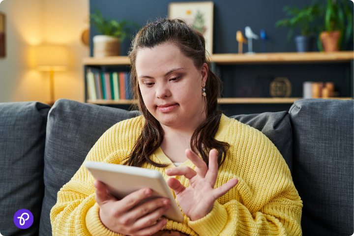 Young woman with Down syndrome using a tablet, highlighting accessible financial tools.