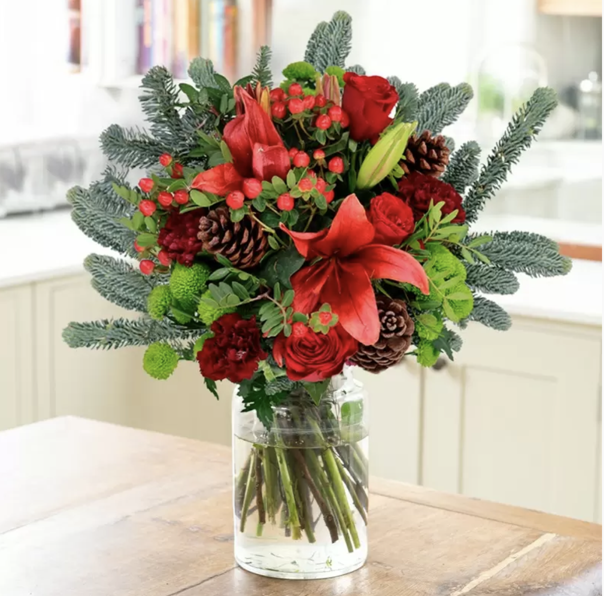 Christmas bouquet of red roses, red lily and fir trees