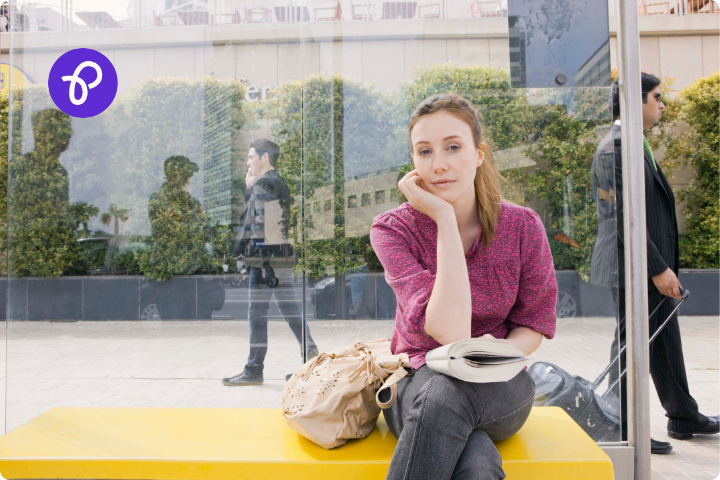 a woman is waiting at a bus stop