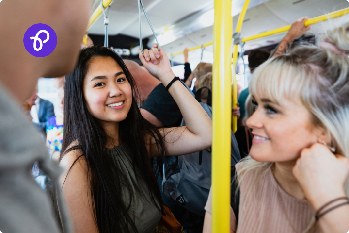 a group of people stood on a bus smiling
