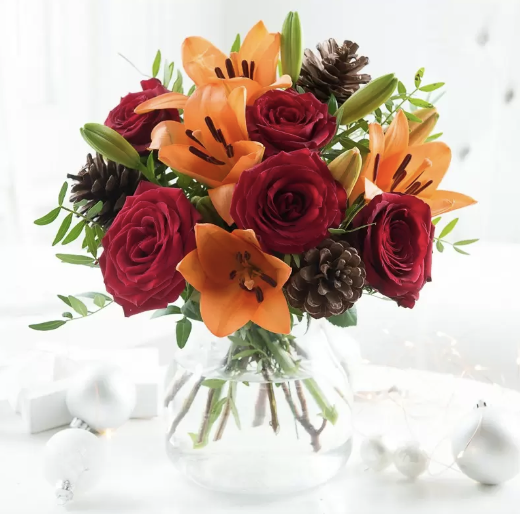 A bouquet of lilies and roses in a christmas bouquet 