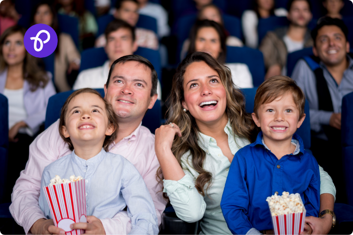 a family of a mum dad and two children are sat in a movie theatre watching a film and eating popcorn for a post about the CEA Card for disabled people