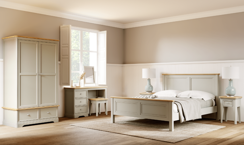 A neutral beige bedroom scene with a bed, bedside table, dressing table and wardrobe all in a grey beige colour