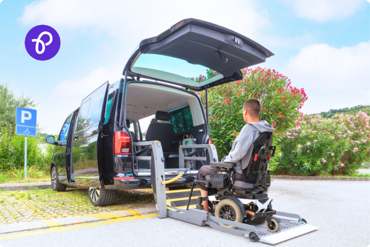 A man is a wheelchair user and is putting his powered wheelchair onto a mobility van using a hoist lift