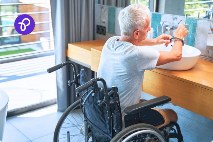 a disabled man with grey hair is using a bathroom at a sink