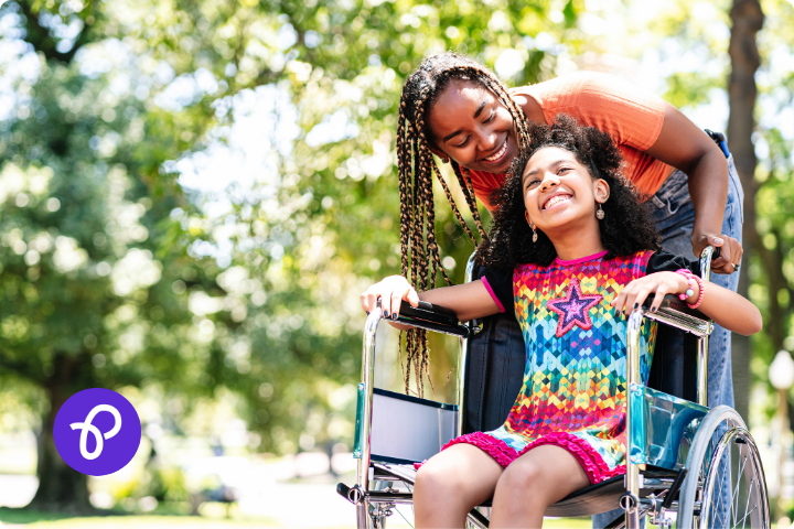 A mother is smiling and pushed her daughter in a wheelchair in a park in a blog post about Mothers Day gift ideas and Purpl Disabled Discounts