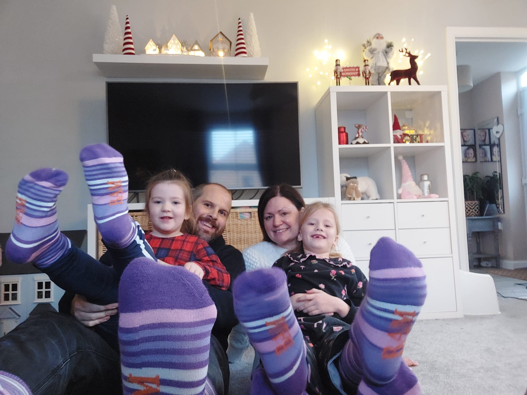 Family at home wearing purple socks to support Purple Sock Day, showing solidarity with people living with disabilities and long term health conditions, alongside awareness of inclusive savings and access to Purpl discounts, shopping discounts for disabled people, disabled travel discounts UK, and mobility discounts and offers.