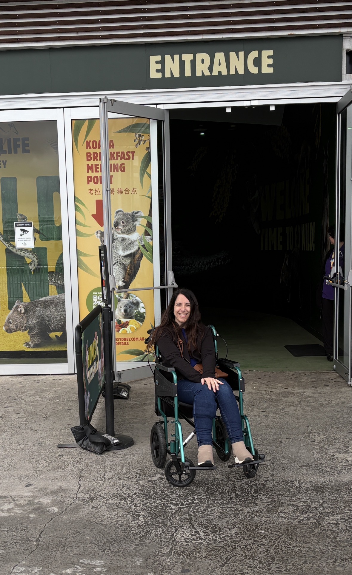 Georgina in a wheelchair outside WILD LIFE Sydney Zoo before the Breakfast with the Koalas experience, highlighting accessible attractions for disabled people visiting Sydney.